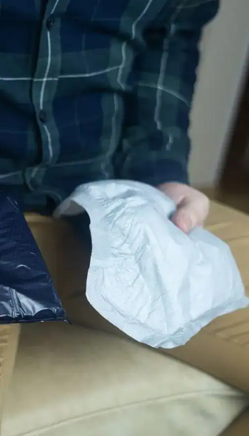 Image of man holding incontinence pads as part of overactive bladder treatment Gloucester